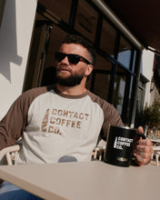 Load image into Gallery viewer, Contact Coffee Baseball Long Sleeve, Cement / Clay - worn outdoors with mug

