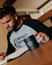 Load image into Gallery viewer, Contact Coffee Baseball Long Sleeve, Heather Grey / Black - worn reading with mug
