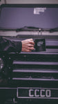  man holding contact coffee co military mug in front of land rover defender